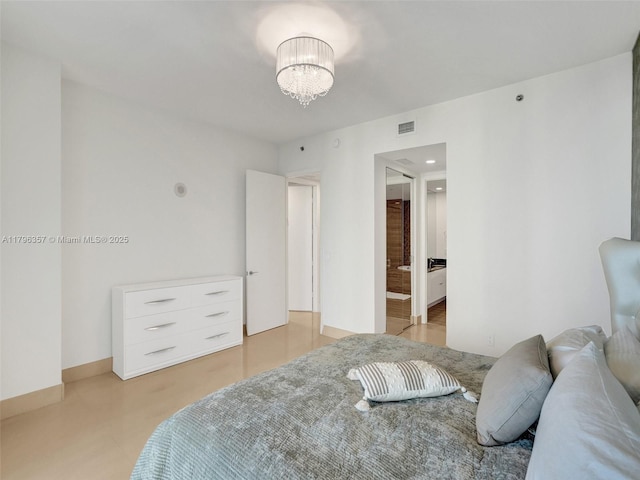 bedroom with a chandelier and connected bathroom