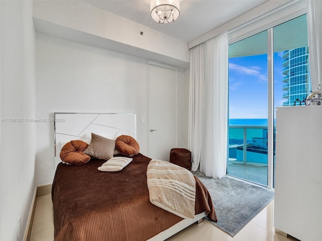 bedroom featuring access to exterior, baseboards, and a water view