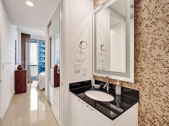 bathroom featuring baseboards, tile patterned floors, and vanity