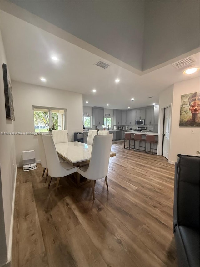 dining space with baseboards, recessed lighting, wood finished floors, and visible vents