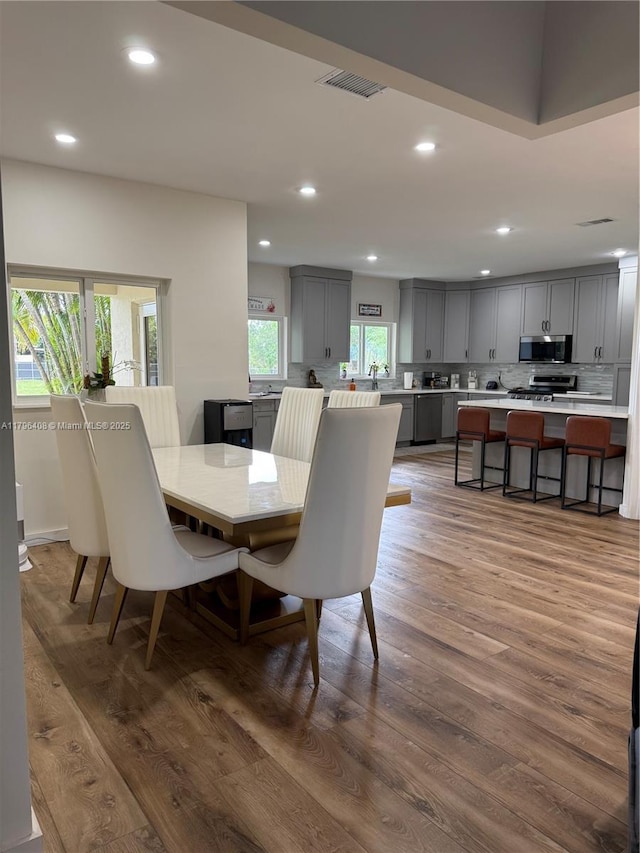 dining room with recessed lighting, wood finished floors, and visible vents