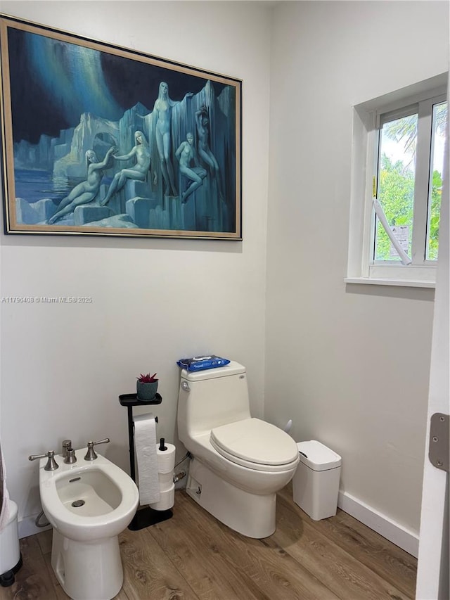bathroom featuring toilet, a bidet, and wood finished floors