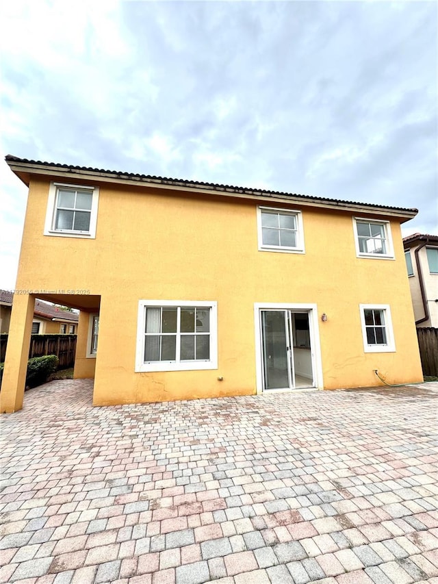 back of property featuring fence, a patio, and stucco siding