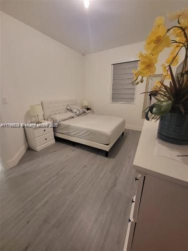 bedroom with baseboards and dark wood finished floors