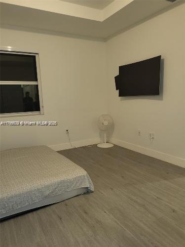 bedroom featuring baseboards and wood finished floors