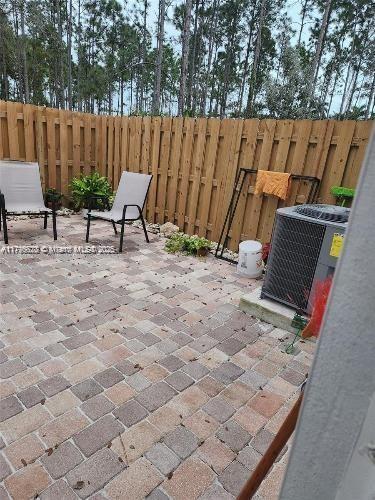 view of patio with fence and central AC unit