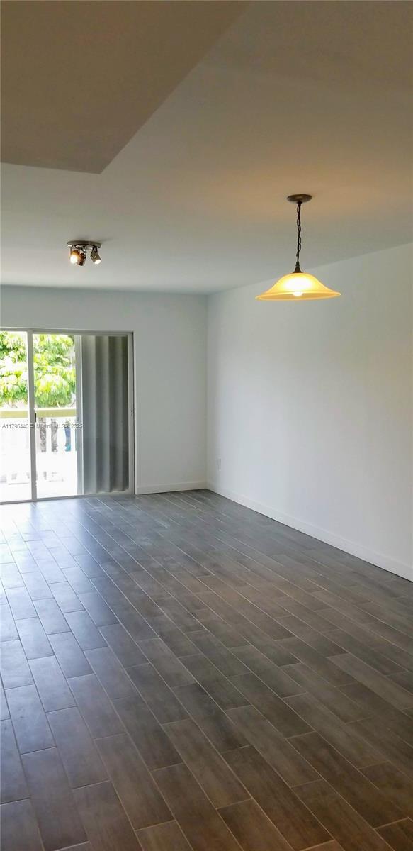 15205 NE 6th Ave Unit D204, Miami, FL 33162 - unfurnished room with baseboards and dark wood finished floors