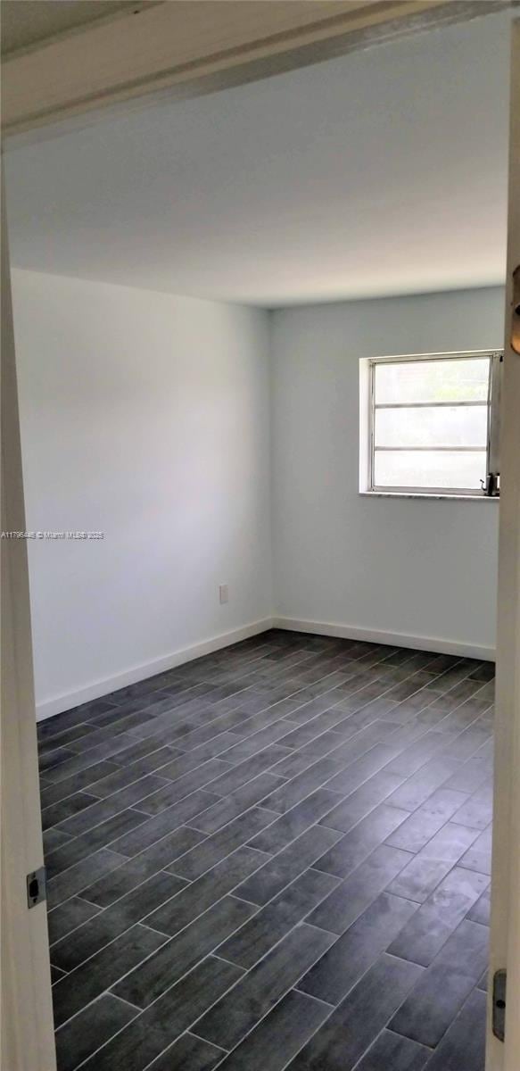 15205 NE 6th Ave Unit D204, Miami, FL 33162 - unfurnished room featuring dark wood-style flooring and baseboards