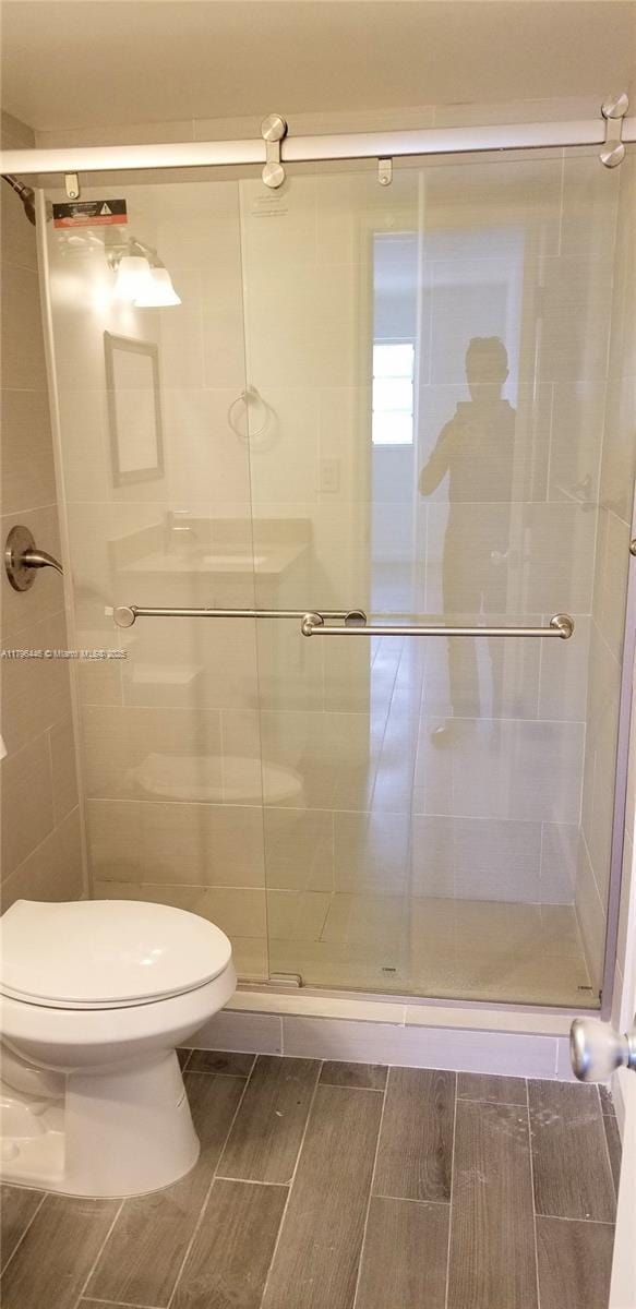 15205 NE 6th Ave Unit D204, Miami, FL 33162 - full bathroom featuring toilet, wood tiled floor, and a stall shower