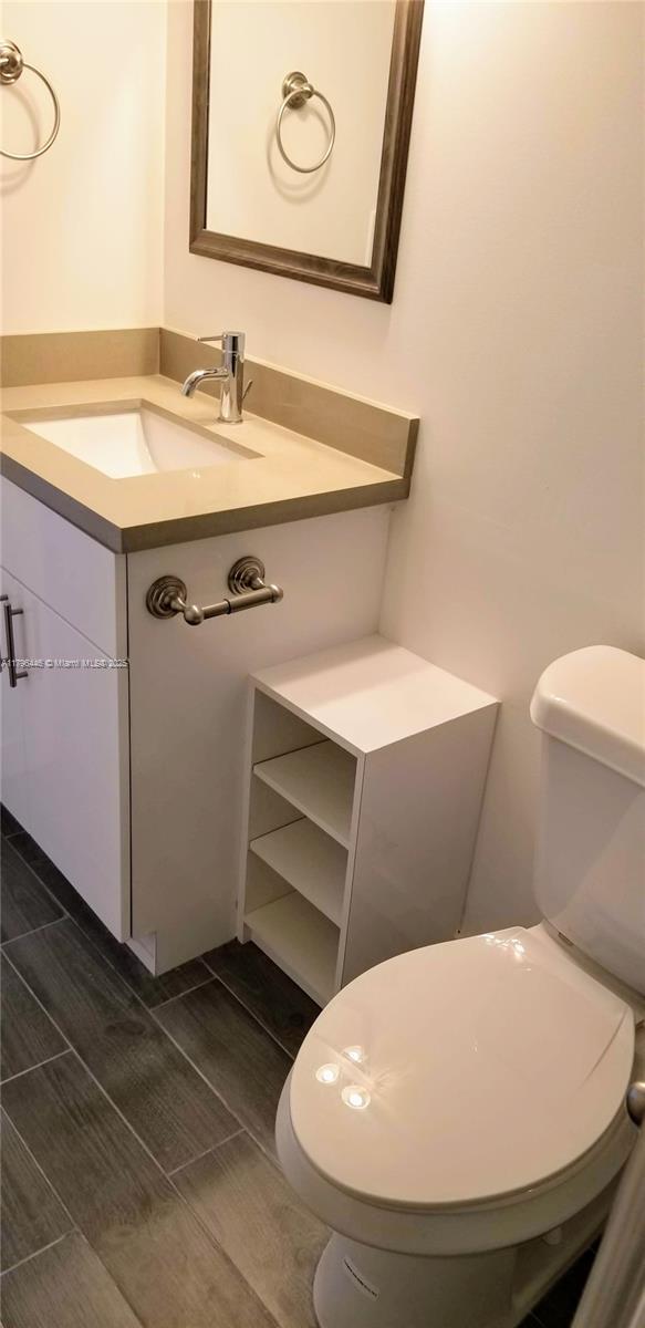 15205 NE 6th Ave Unit D204, Miami, FL 33162 - bathroom featuring toilet, vanity, and wood finish floors