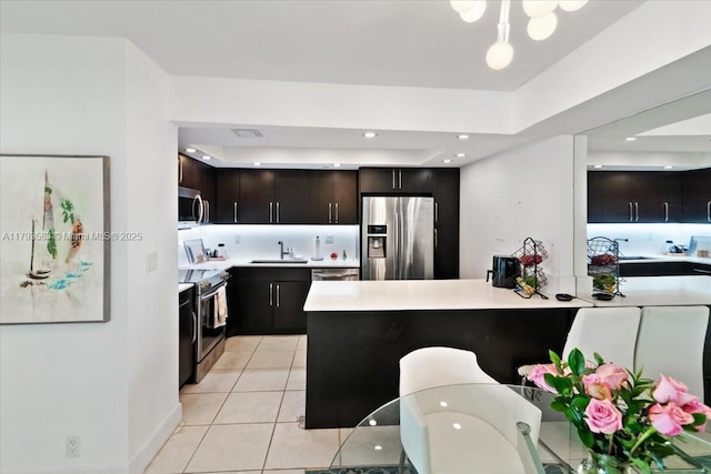 4000 Towerside Ter Unit 704, Miami, FL 33138 - kitchen with appliances with stainless steel finishes, light countertops, light tile patterned floors, recessed lighting, and dark brown cabinets