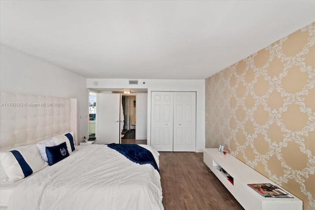 4000 Towerside Ter Unit 704, Miami, FL 33138 - bedroom with visible vents, a closet, wallpapered walls, and wood finished floors
