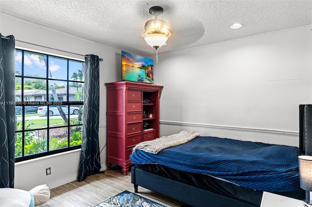 11377 NW 21st Ct, Coral Springs, FL 33071 - bedroom featuring light wood-style floors, a textured ceiling, and baseboards