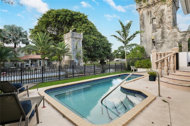 view of swimming pool with a patio, a fenced in pool, and fence