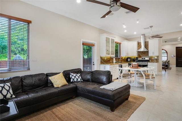 living area with light tile patterned flooring, crown molding, a ceiling fan, and recessed lighting