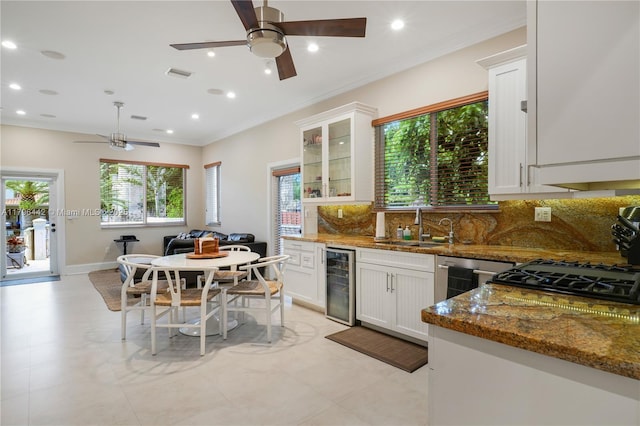 kitchen featuring wine cooler, visible vents, ceiling fan, a sink, and tasteful backsplash
