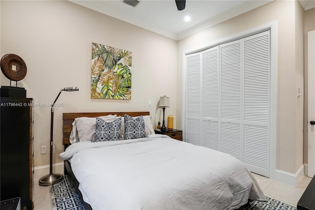 bedroom featuring light tile patterned floors, a closet, crown molding, baseboards, and ceiling fan