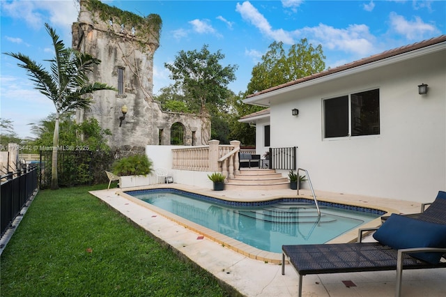 view of pool with a yard, fence, a wooden deck, and a fenced in pool