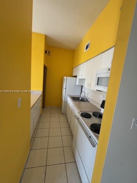 7400 W 20th Ave Unit 326, Hialeah, FL 33016 - kitchen featuring white appliances, white cabinetry, tasteful backsplash, a sink, and light tile patterned floors