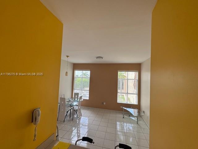 7400 W 20th Ave Unit 326, Hialeah, FL 33016 - hallway featuring light tile patterned flooring and baseboards