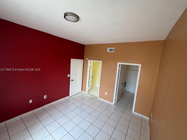 7400 W 20th Ave Unit 326, Hialeah, FL 33016 - empty room with baseboards, light tile patterned floors, and an accent wall