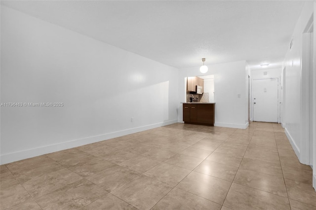 716 Michigan Ave Unit 204, Miami Beach, FL 33139 - kitchen with freestanding refrigerator, light countertops, light tile patterned floors, and dark brown cabinetry