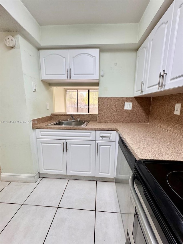 kitchen with light tile patterned floors, white cabinets, appliances with stainless steel finishes, and a sink