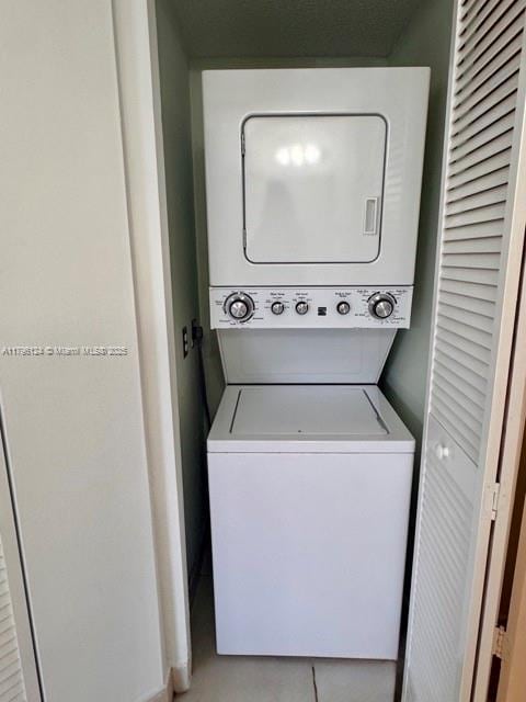 clothes washing area with laundry area and stacked washer / drying machine