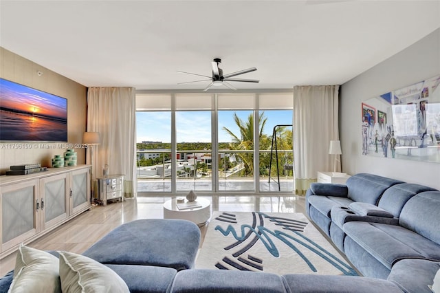 living area featuring a ceiling fan, a wall of windows, light tile patterned floors, and plenty of natural light
