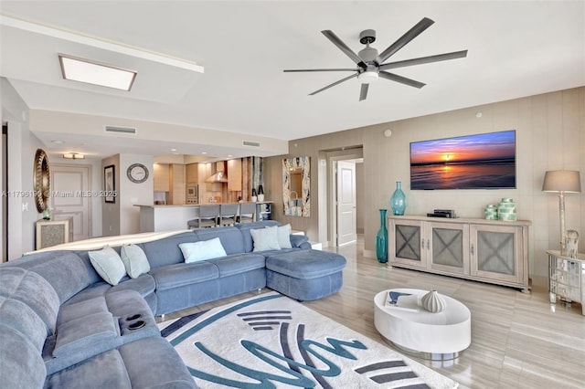 living area featuring visible vents and a ceiling fan