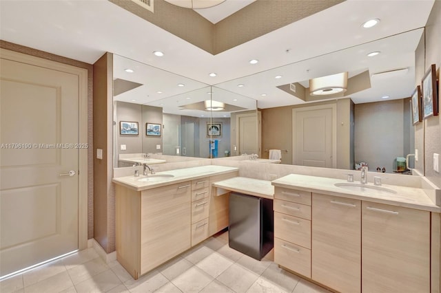 full bath featuring tile patterned floors, two vanities, and a sink