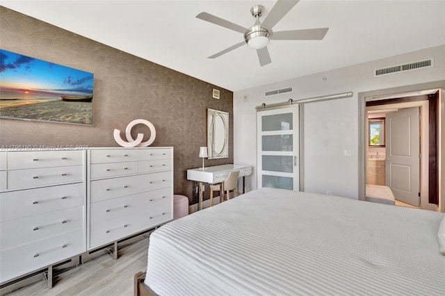 bedroom with light wood-style flooring, a ceiling fan, visible vents, and wallpapered walls