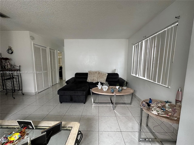 living area featuring a textured ceiling and visible vents