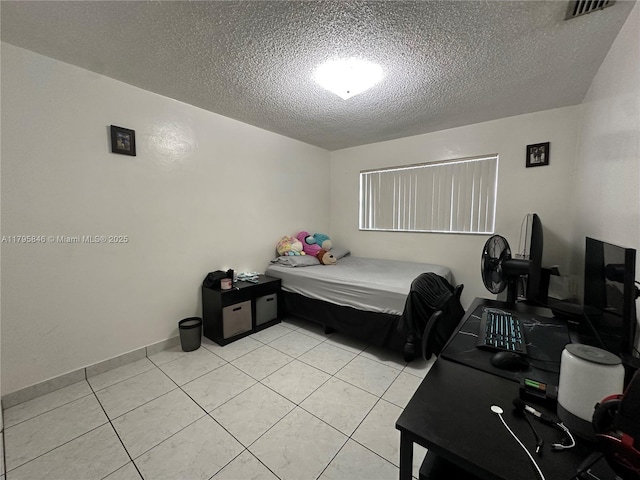 bedroom with a textured ceiling, light tile patterned flooring, and visible vents