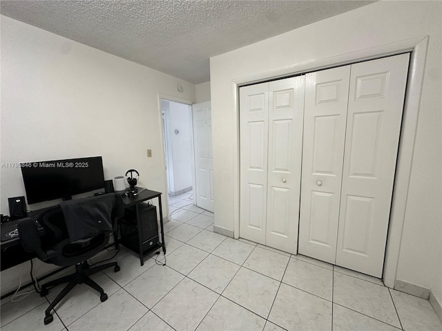 office with light tile patterned floors and a textured ceiling