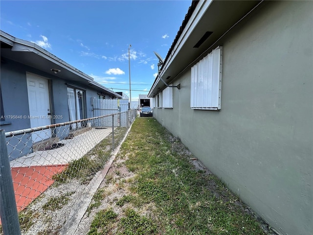 view of side of property with fence and stucco siding