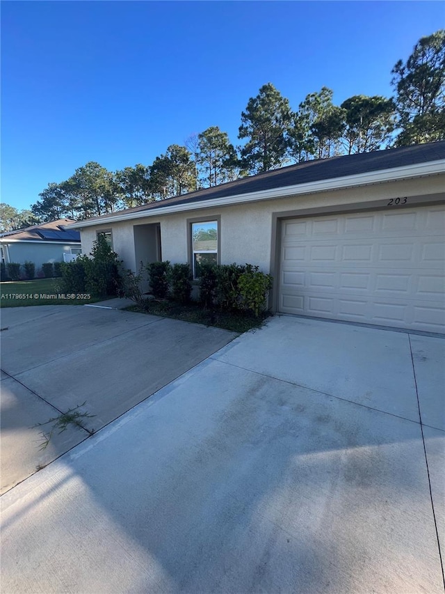 203 Palmwood Dr, Palm Coast, FL 32164 - ranch-style home featuring concrete driveway, stucco siding, and a garage
