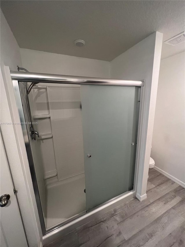 203 Palmwood Dr, Palm Coast, FL 32164 - full bath featuring baseboards, wood finished floors, a shower stall, and visible vents