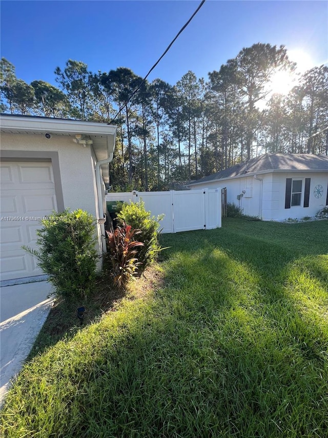 203 Palmwood Dr, Palm Coast, FL 32164 - view of yard with a gate, fence, and an attached garage