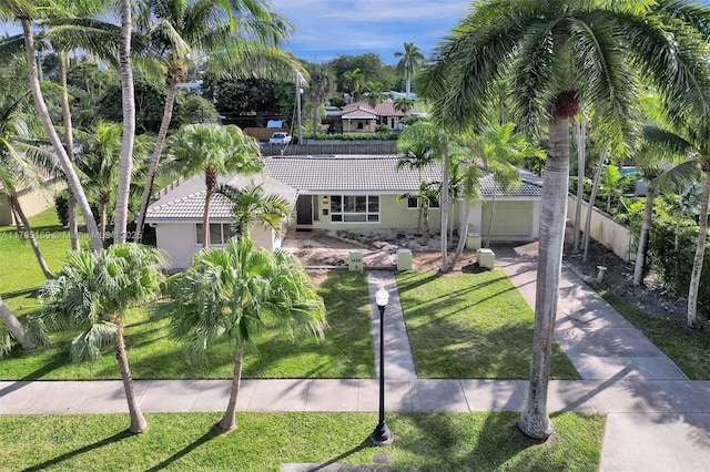 1438 Harrison St, Hollywood, FL 33020 - view of front of home with a tiled roof, concrete driveway, stucco siding, and a front yard