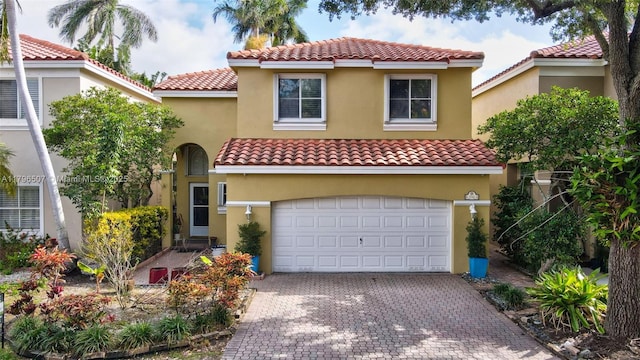 1741 E Trafalgar Cir, Hollywood, FL 33020 - mediterranean / spanish home featuring an attached garage, decorative driveway, stucco siding, and a tiled roof