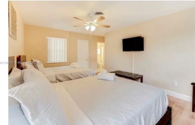 bedroom featuring baseboards, visible vents, a ceiling fan, and wood finished floors