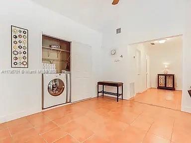 washroom with washing machine and clothes dryer, laundry area, visible vents, and tile patterned floors