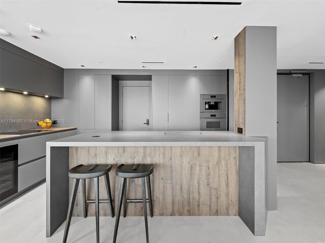 3101 S Ocean Dr Unit 2905, Hollywood, FL 33019 - kitchen with modern cabinets, gray cabinetry, double oven, and a kitchen bar