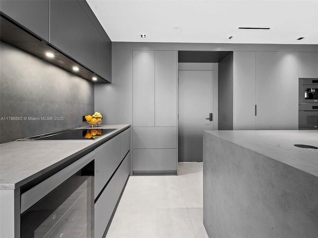 3101 S Ocean Dr Unit 2905, Hollywood, FL 33019 - kitchen featuring beverage cooler, modern cabinets, black electric stovetop, double wall oven, and gray cabinetry