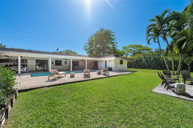 back of house with a yard, a patio, an outdoor pool, and ceiling fan