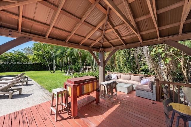 wooden terrace with outdoor lounge area, a patio area, a gazebo, and a lawn