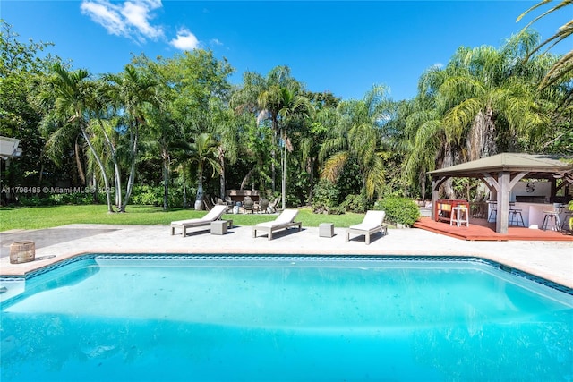 pool with a gazebo, a patio area, and a lawn