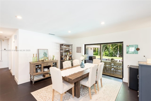 dining space featuring dark tile patterned floors, baseboards, and recessed lighting
