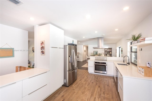 kitchen with a sink, visible vents, modern cabinets, and appliances with stainless steel finishes